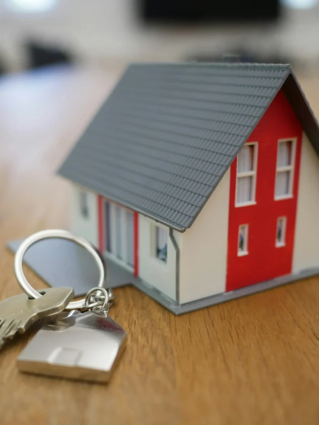 Miniatura de casa de madeira branca e vermelha sobre mesa marrom, capa de um webstories sobre ITBI