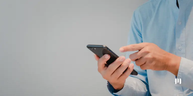 Trabalhador utilizando o celular para consultar informações sobre o lote complementar do Abono Salarial.