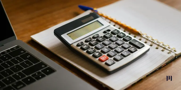Calculadora sobre um caderno aberto, ao lado de um notebook, ilustrando o tema renegociação de dívidas.